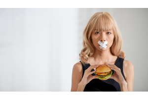 Zbliżenie kobiety z zaklejonymi ustami trzymającej burgera
