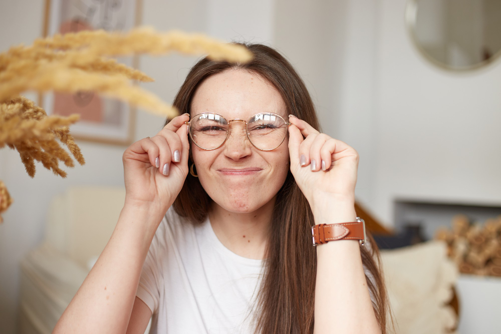 Młoda kobieta w okularch robi śmieszną minę